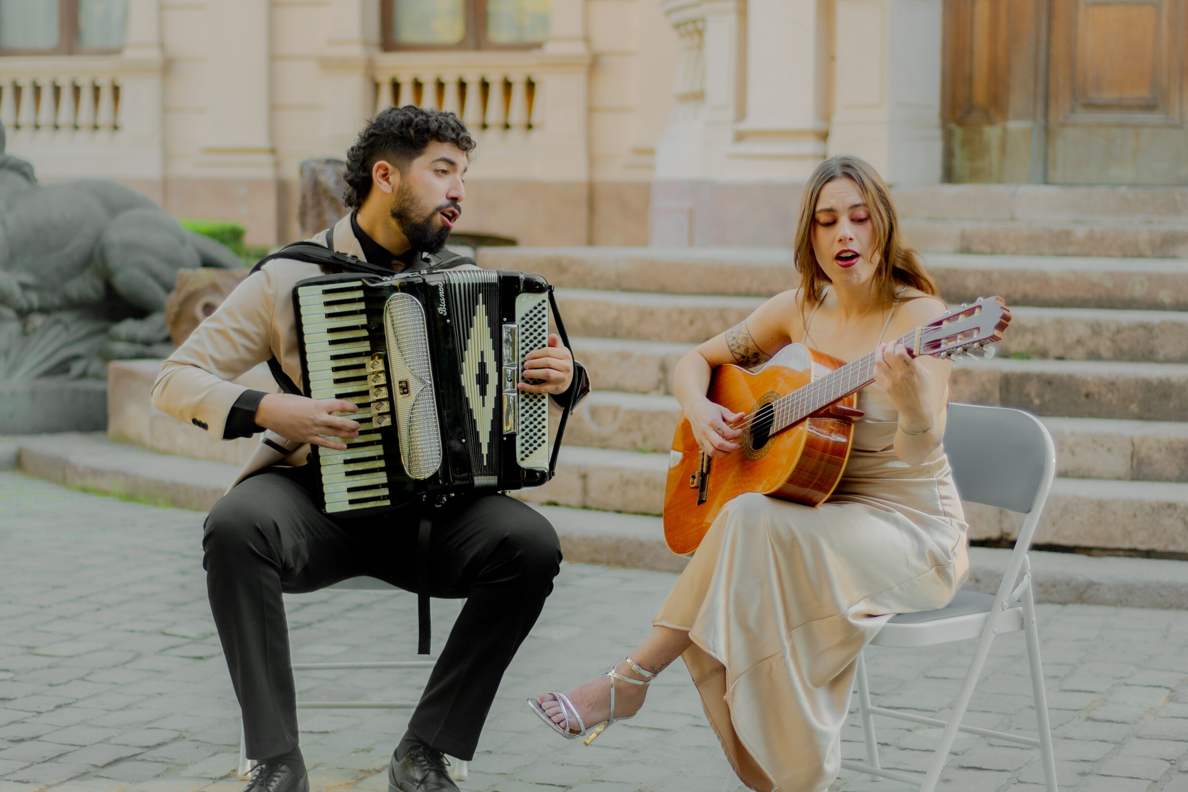 Dúo Amores de Chile tocando acordeón y guitarra en el histórico Palacio Cousiño de Santiago.