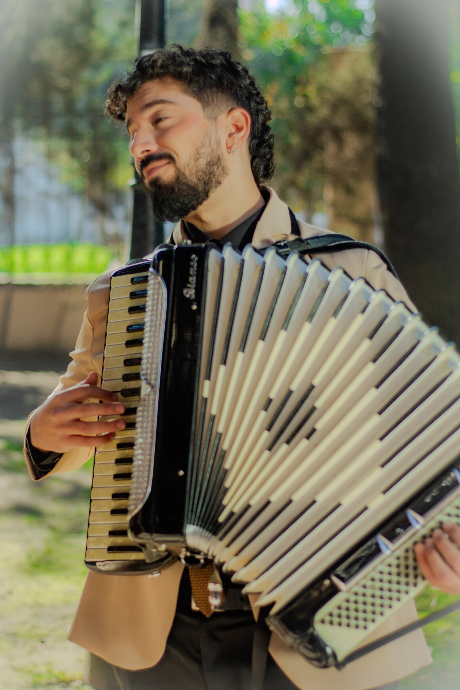 Músico del Dúo Amores de Chile tocando el acordeón con alegría en los jardines del Palacio Cousiño.