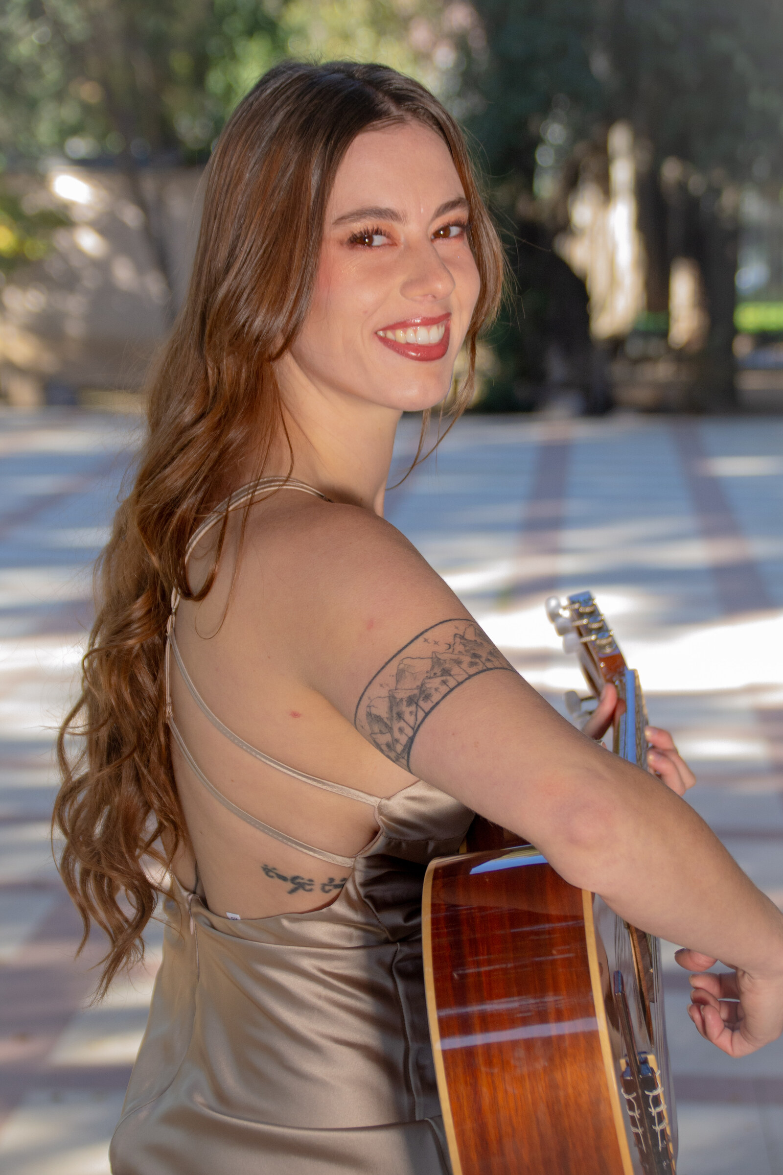Cantante de Dúo Amores de Chile sonríe con su guitarra, mostrando su alegría en el Palacio Cousiño.